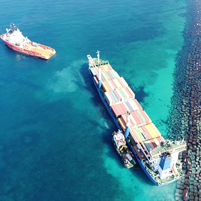 Rescue boat pilots away from vessel full of shipping containers